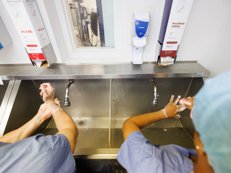 New surgery residents Dr. Kyle Deivert and Dr. Ahsia Clayton practice scrubbing in. Melanie Thortis/ UMMC Communications